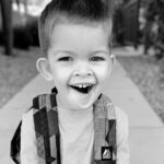Little boy sitting on the step smiling