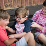 Three brothers playing on a sofa