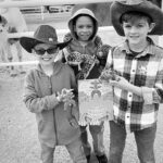 Three boys holding prize