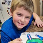 Little boy showing off his art