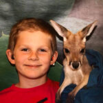 Smiling boy with baby kangaroo