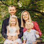 Family posing on park bridge