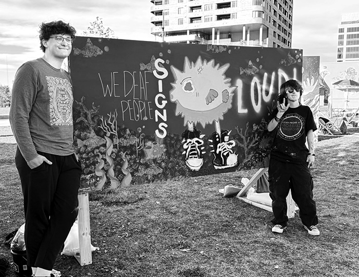 Artists in front of art mural
